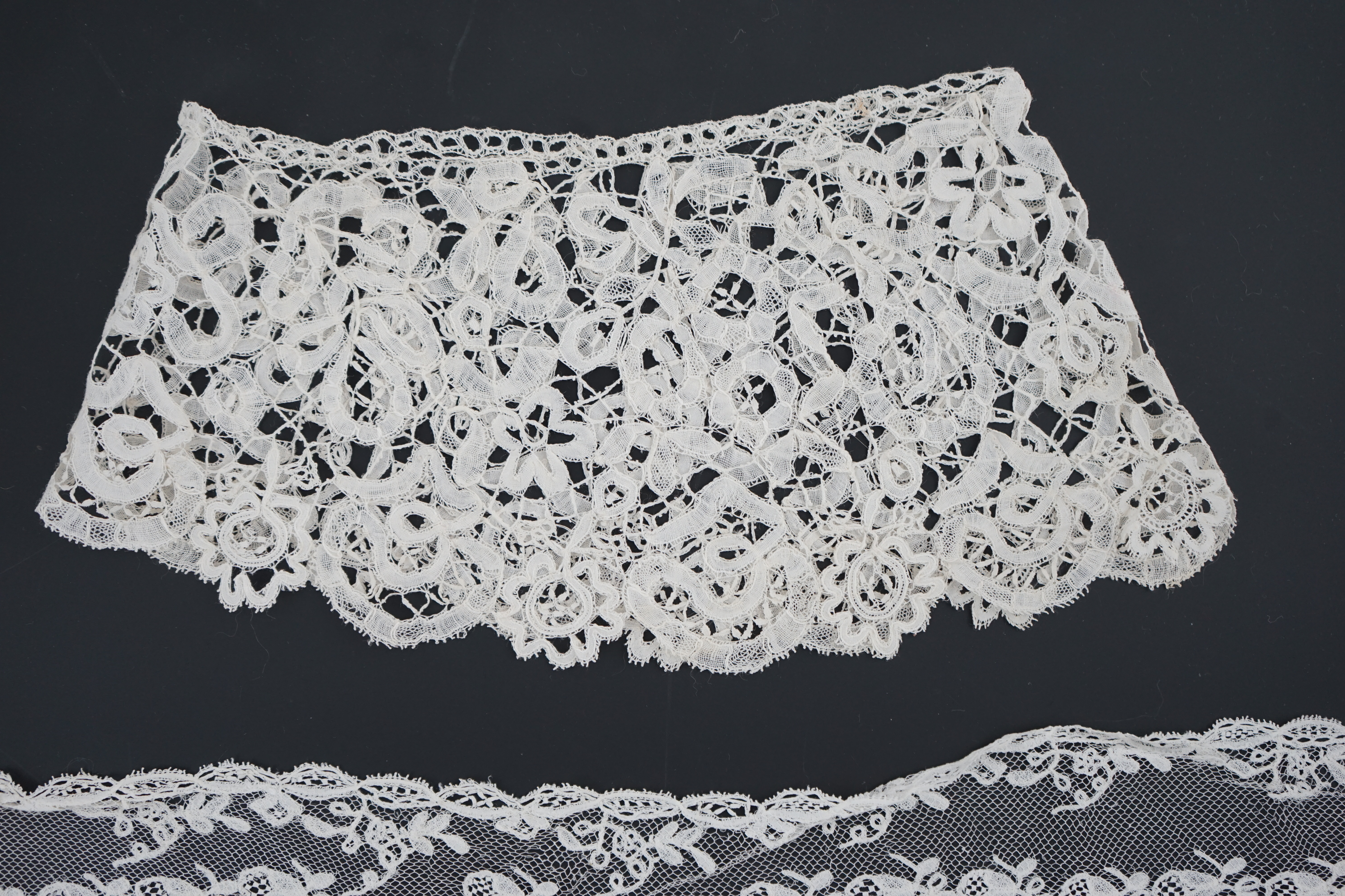 A small collection of late 19th century laces including a cream Brussels bobbin lace collar appliquéd on to net and two similar Brussels bobbin lace lappets, a pair of cream Honiton bobbin lace cuffs and a black lace fal